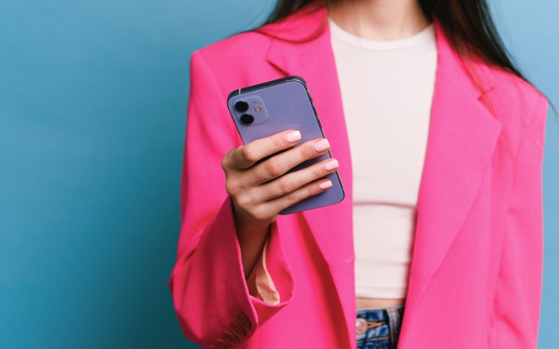 Mulher no telefone celular fazendo pix para vaquinha online