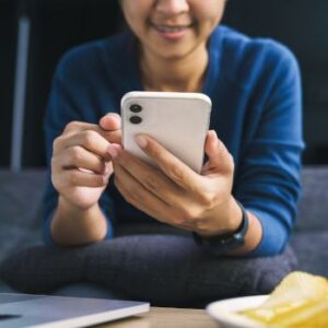 Mulher no celular na mão sorrindo vaquinha pix